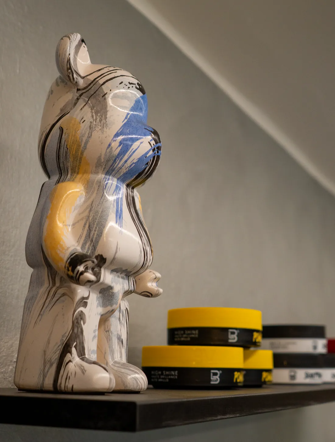 Figura de colección y ceras para el pelo en una estantería