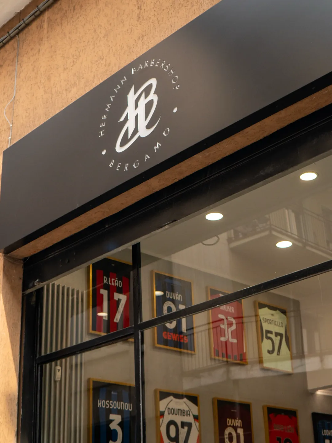 L’enseigne Hermann Barbershop au-dessus de la vitrine Via Casalino